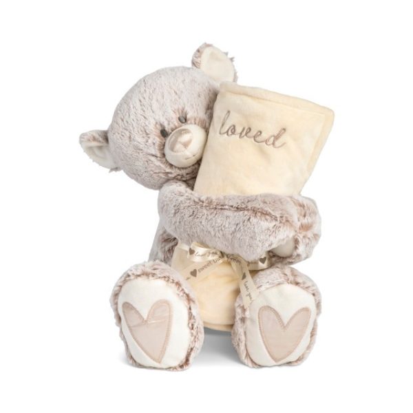 A light brown teddy bear with a light brown nose and light brown hearts on its paws holding a rolled soft light yellow blanket that says "loved".