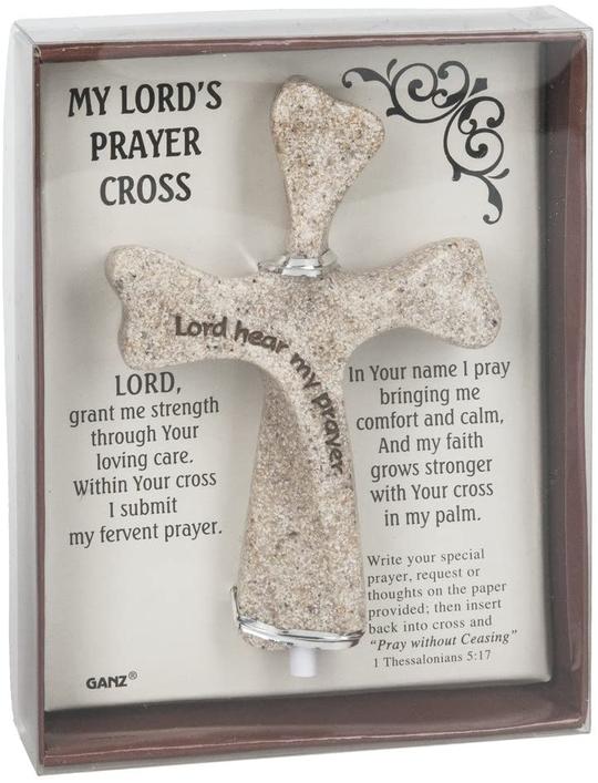 Brown box with clear cover, inside carboard piece is white with black script and decorative accent, containing a 4" tan resin cross with black font inscribed on it.